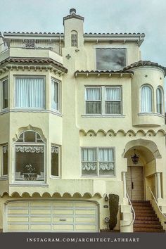 a large white house with stairs leading up to it's front door and windows