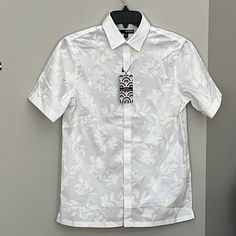 From Murano, This Shirt Features: Leaf Print Point Collar Short Sleeves Hidden Button-Front Closure Covered Placket 100% Cotton Machine Wash/Tumble Dry Imported. Color Is Ecru Approx: Pit To Pit 38” Length 27” Fitted White Tops With Placket, Elegant Short Sleeve Floral Shirt, Classic Collared Tops With Floral Print, Fitted Collared Shirt With Floral Print, White Fitted Short Sleeve Casual Shirt, Classic Fitted Floral Print Tops, Elegant Short Sleeve Floral Print Shirt, Fitted Summer Shirt With Placket, White Casual Short Sleeve Shirt