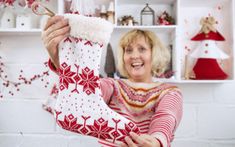 a woman holding up a christmas stocking in her hands