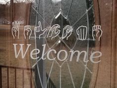 a glass door with the words welcome written on it