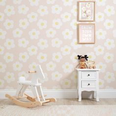 a child's room with a rocking horse and flower wallpaper