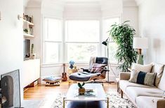 a living room filled with furniture and a fire place in front of a large window