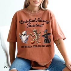 a woman sitting on top of a chair wearing an orange shirt with three halloween characters