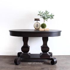 a table with a clock on it next to a plant