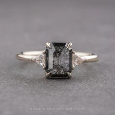 a black and white diamond ring with three stone accents