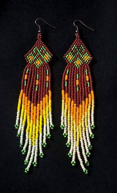 two pairs of beaded earrings with fringes and beads on black background stock photo