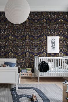 a baby's room with a white crib and blue wallpaper on the walls