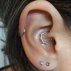 a woman with two piercings on her ear and one behind the ear is a crescent