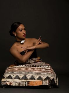 a woman sitting on top of a cushion with her hands out in front of her