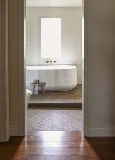 an open door leading to a bathroom with a bathtub