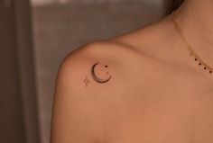 a woman with a small crescent tattoo on her left shoulder and the moon behind it