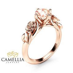 a rose shaped engagement ring with an oval center stone and two small flowers on the side