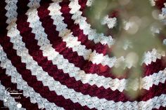 a red and white crocheted blanket is shown