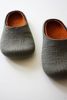 two gray slippers sitting on top of a white table