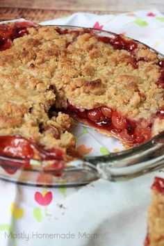 a pie with a slice taken out of it on a floral table cloth next to a fork