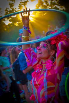 a woman is holding a hula hoop above her head