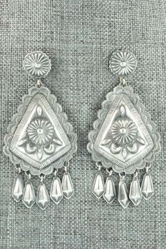 These sterling silver earrings were made by Navajo silversmith Terry Charlie. The back of the earrings are signed T. Charlie and stamped sterling.Length: 2 7/8"Width: 1 3/8"Free shipping on all orders! We ship with USPS and always include tracking. All orders ship within a day of payment.Returns are accepted up to 30 days after you receive your order. Just send us a message. Our shop offers cash back or store credit. The item must be returned in new condition. Silver Teardrop Concho Earrings, Traditional Silver Etched Earrings, Traditional Etched Silver Earrings, Silver Concho Drop Earrings, Silver Concho Dangle Earrings, Silver Dangle Earrings With Concho, Southwestern Silver Concho Earrings, Vintage Sterling Silver Etched Earrings, Vintage Etched Sterling Silver Earrings