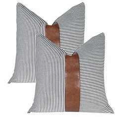 two black and white striped pillows with brown leather accents