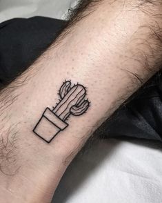 a small cactus tattoo on the wrist