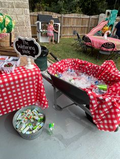 a red and white checkered table cloth covered wagon with coolers on the side