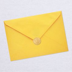 an open yellow envelope with a wax stamp on it