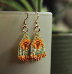 Orange and blue/green beaded earrings - Two tones of orange beads with semi-clear blue/green background - Beaded earrings handmade with care Handmade Orange Teardrop Beaded Earrings, Orange Teardrop Beaded Earrings With Ear Wire, Orange Teardrop Beaded Earrings With Dangling Beads, Orange Beaded Earrings With Round Beads, Orange Round Beaded Earrings With Ear Wire, Orange Teardrop Beaded Earrings, Orange Faceted Beads Earrings For Gifts, Orange Faceted Beaded Earrings For Gift, Orange Beaded Earrings With Tiny Round Beads