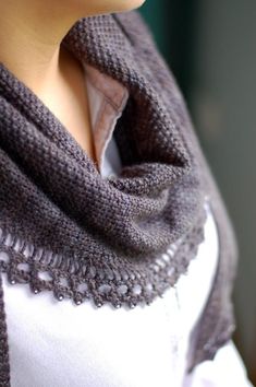 a close up of a woman wearing a knitted shawl with lace trims