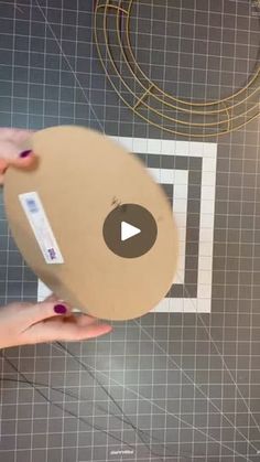 two hands are holding a cardboard disc