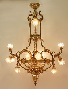 an ornate chandelier hanging from the ceiling in a room with white walls and flooring