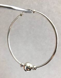 "Simple and classic Cape Cod style round solid sterling silver hoop earring ball beads. I assemble this earring with two 5mm and one 10mm sterling silver bead finish it with a 53mm endless hoop. Hoop dimension: 54mm (2 1/8\") hoop tube thickness: 2mm (3/32\") Bead size: 2 x 5mm and 1 x 10mm Quantity: 1 pair = 2 pieces stamped: 925 (marking of sterling silver) This earrings will send with a gift box. We are not affiliated with Eden Hand Art of Dennis, MA, the creator of the Cape Cod Jewelry." Hypoallergenic Sterling Silver Hoop Earrings With Round Beads, Hypoallergenic Silver Hoop Earrings, Silver Cape, Cape Cod Jewelry, Silver Hoop Earring, Locket Ring, Earring Hoop, Sterling Silver Locket, Silver Lockets