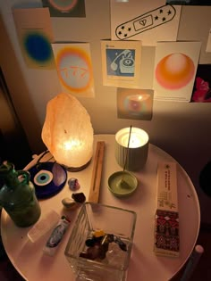 a table topped with lots of different items on top of a white round table next to a wall