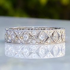 Details: Beautiful lacy delicate diamond and platinum eternity band. This band is super sparkly, and very feminine. The band is 4.4mm wide, with bead set diamonds with mill grain edging and hand engraved side profile. Every detail on this one is lovely. You'll be pleased to add this beauty to your collection. This ring comes with an appraisal. Appraisal Notes: Thirteen round brilliant diamonds measuring 1.6 x 1.6 x .96mm, approx. weight .19ct. Twenty-six round brilliant diamonds measuring 1.1 x Wedding Diamond Jewelry With Milgrain, Wedding Diamond Milgrain Jewelry, Milgrain Diamond Wedding Jewelry, Luxury Rose Cut Diamonds Eternity Band For Formal Events, Fine Jewelry Wedding Rings With Milgrain Detail, Elegant Milgrain Diamond Ring For Wedding, Elegant Milgrain Diamond Wedding Ring, Heirloom Diamond Cut Bands, Classic Diamond Eternity Band With Decorative Design