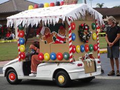 a car decorated with christmas decorations and candy canes is parked in front of a man