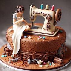 a birthday cake with a sewing machine on it and a woman sitting at the table