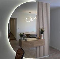 a room with a mirror, table and chair in the center is lit up by lights