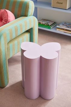 two stools sitting next to each other in front of a green chair and striped couch