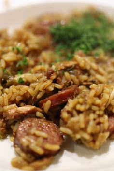 a white plate topped with rice and sausage