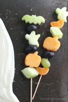 fruit skewers are arranged on a plate