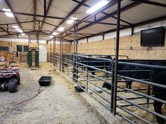 the inside of a barn with cows and other animals in it, including an atv