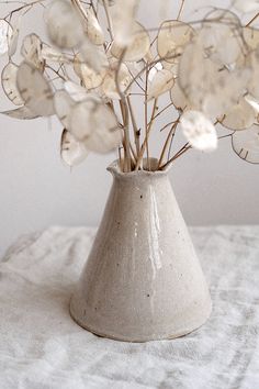 a white vase filled with flowers on top of a table