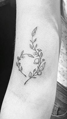 a black and white photo of a flower tattoo on the left side of the arm