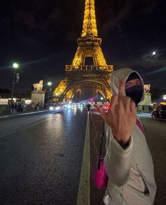 a person taking a photo in front of the eiffel tower