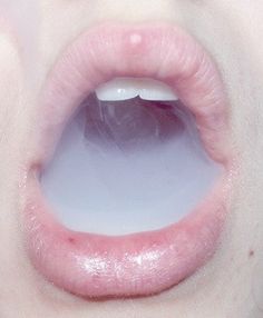 a close up view of a person's mouth with white and pink lipstick on it