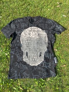 Wonderful black T-Shirt Design Philipp Plein, Italy 2002. Stretch cotton T-shirt with the typical skull, unique pattern. Excellent condition, like new! Quality without the audacity of his typical designs. Incredible colors, vivid, are clean and free of any problems. Our products can be used immediately without any problem, there is no dust, smell or anything like that. All products in our shop are guaranteed to be 100% original and authentic. The product that will be shipped is exactly what you Black Short Sleeve T-shirt With Skull Print, Urban Skull Print Crew Neck T-shirt, Skull Graphic Tee With Text Print, Black Short Sleeve Top With Skull Print, Urban Crew Neck T-shirt With Skull Print, Black Punk T-shirt With Skull Print, Punk Black T-shirt With Skull Print, Urban Skull Print Crew Neck Top, Black Skull Print Graphic Tee