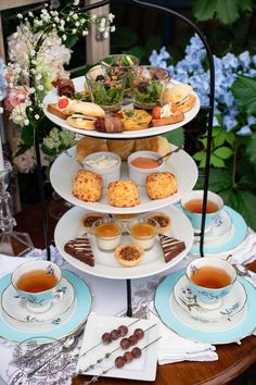 three tiered trays filled with pastries and tea on top of a table