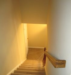 an empty hallway with stairs leading up to the door