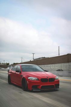 a red car is driving down the road