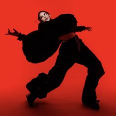 a person is doing a trick on a skateboard in front of a red background