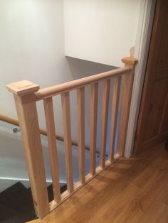 a wooden banister next to a white wall