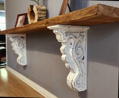 two wooden shelfs on the wall with decorative designs and wood trimming around them